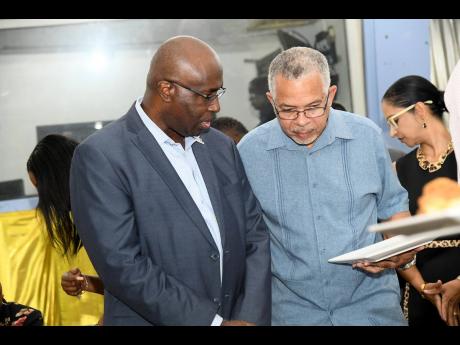 Gary Allen (left), CEO of RJRGLEANER Communications Group, has the ear of journalist Earl Moxam at the J. A. Lester Spaulding Lecture event.