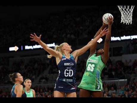 Sunshine Girl and West Coast Fever’s Jhaniele Fowler (right) makes a catch ahead of  Melbourne Vixens’ Jo Weston during their Suncorp Super Netball League eight-round game on Sunday.