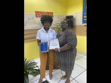 From concept to completion, Jo-Ann accepts the award for having the best entrepreneurial mindset from Jamaica Business Development Corporation. She is joined by her supportive mother, Charmaine.