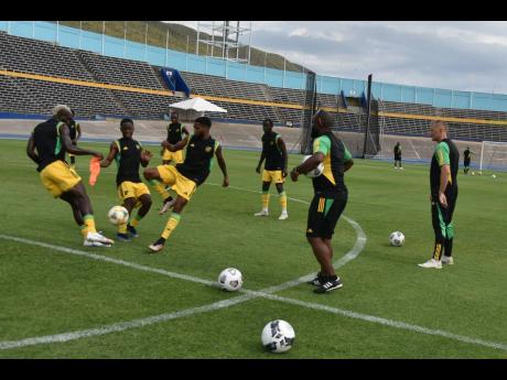 The Reggae Boyz, watched by head coach Heimir Hallgrimsson (right), during a training session at the National Stadium on March 7, 2023.