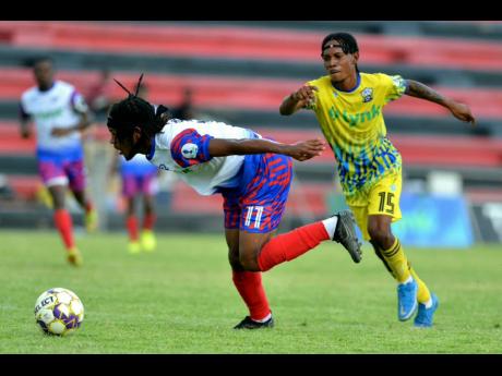 
Portmore United’s Alex Marshal (left) stumbles past Molynes United’s Joshua Dewar during a Lynk Cup quarterfinal at the Anthony Spaulding Sports Complex recently.