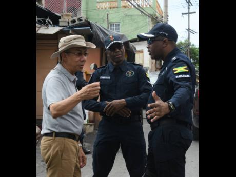 Dr Horace Chang (left), minister of national security, in dialogue with Assistant Commissioner of Police Clifford Chambers (centre) and Senior Superintendent of Police Vernon Ellis during a tour of the violence-torn community of Mount Salem in St James on 