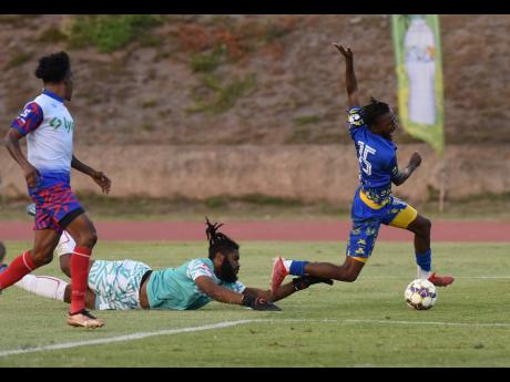 Odorland Harding (right) of Harbour View is fouled by Portmore United’s goalkeeper William Benjamin during their Lynk Cup semi-final match at the Stadium East field last Friday. Looking on at left is Alvinus Myers of Portmore United.