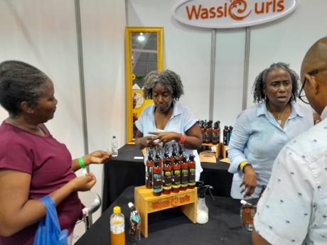 Amethyst Concepts has two lines of hair and skin products - WassCurls for women and BREDREN for men. Here, representatives Colleen Sybblis (left) and Andrea Sybblis chat with patrons at the recent Expo Jamaica 2023 about their locally manufactured products