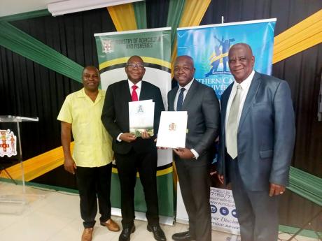 Minister of Agriculture and Fisheries Pearnel Charles (2nd right) and Northern Caribbean University President, Dr Lincoln Edwards (2nd left) exchange signed copies of an MOU to develop a National Organic Agriculture Policy. They are flanked by Permanent Se