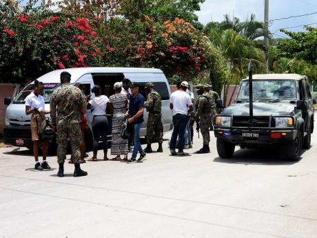 Passengers travelling on a minibus being searched at a checkpoint at Wiltshire in Greenwood, St James, by members of the Jamaica Defence Force (JDF) yesterday. A state of public emergency has been declared in Clarendon, Hanover, and St James.
