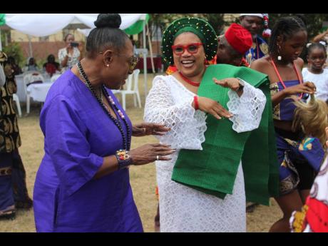 Minister of Culture, Entertainment, Gender and Sport Olivia Gange (left), and Nigerian High Commissioner to Jamaica Dr Maureen Tamuno kicking up a dancing storm during the Nigeria Cultural Day event on the lawns of the Nigerian High Commission along Waterl