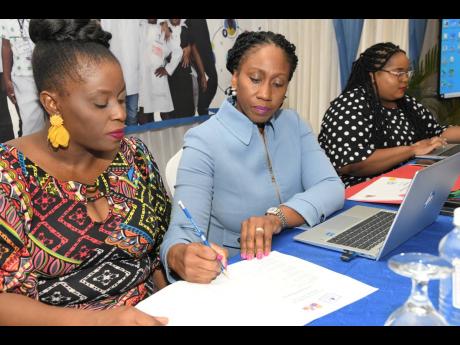Children’s Advocate Diahann Gordon Harrison (centre) checks her data with Latoya Minott-Hall (left), public education and special projects manager at the Office of the Children’s Advocate (OCA), and Anna-Maria Dawkins-Johnson, quality assurance coordin