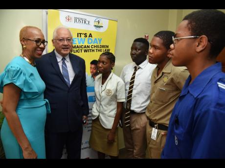 Fayval Williams (left), Minister of Education and Youth, and Delroy Chuck (second left), Minister of Justice, address students from high schools in the Corporate Area about restorative justice, at the Child Diversion Forum at Hotel Four Seasons yesterday. 
