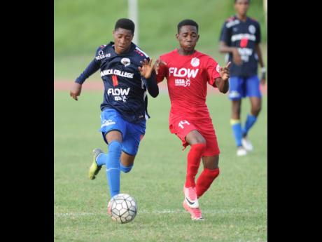 In this 2017 file photo Jamaica College’s Norman Campbell (left) dribbles away from  Bridgeport High’s Tyrese Wynter during a Manning Cup match at the Stadium East field.