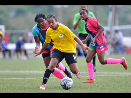 Cavalier’s Liha Williams (centre) gets away from Nevillegail Able from Frazsiers Whip during the Jamaica Women’s Premier League KO final at the UWI-JFF Captain Horace Burrell Centre of Excellence last Saturday. Frazsiers Whip won the match 2-1.