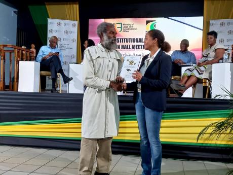  Marlene Malahoo Forte, minister of legal and constitutional affairs, accepts a document called ‘We the People Propose Constitutional Reform in Jamaica’ from author Haile Mika’el Cujo during a Constitutional Reform Committee Town Hall Meeting in Mand