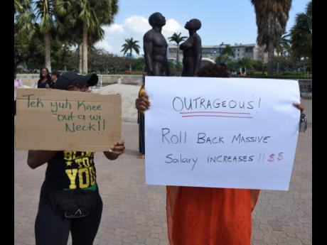 Persons demonstrate outside Emancipation Park in New Kingston yesterday. 