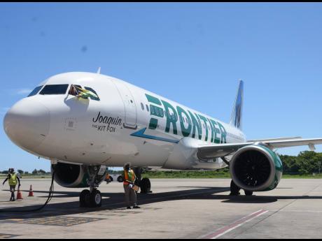 Captain Justin Brack Neff of Frontier Airlines waves the Jamaican flag as he arrives on the inaugural flight from Dallas-Fort Worth International Airport in Dallas, Texas, to the Sangster International Airport in Montego Bay on Monday, May 22.
