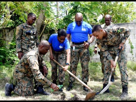Members of the Jamaica Defence Force (from left); Carlos Henry, Shyhiem Waldron, Major Jennifer McKenzie, Major Anthony Lysight, Warrant Officer Class 2 Greig Griffiths and Aston Slue take part in the tree planting exercise at Salt Spring Primary & Infant 