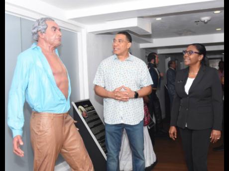 Holness visits the icons of S Hotel. Here he looks at former Prime Minister Alexander Bustamante along with general manager at the Montego Bay resort, Ann-Marie Goffe-Pryce.