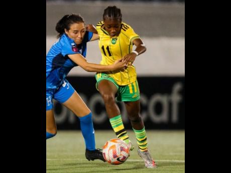 Jamaica’s Shaneil Buckley (right) goes past a Honduran player during the final Group E game of their Concacaf Under-20 Women’s Championship qualifier in Nicaragua last month.