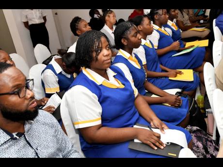 Romane McLeod (left), teacher, and Theodosia Millwood (second left), student of St Hugh’s High School, look on with other students at the Child Protection and Family Services Agency (CPFSA) Ananda Alert Youth Forum, at Altamont Court hotel in New Kingsto