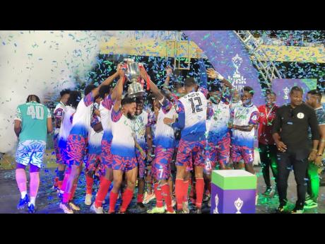 Portmore United's players celebrate lifting the Lynk Cup trophy after a 2-0 win over Cavalier at sabina Park this evening.