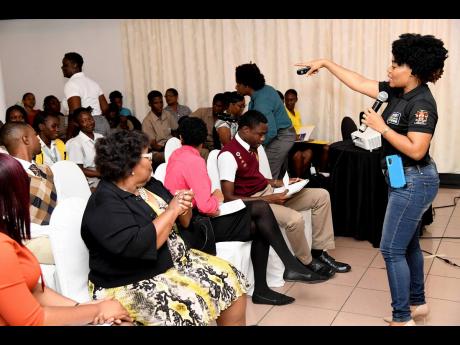 Judine Webb-Brown (right), children’s officer at the Child Protection and Family Services Agency, interacts with students at the Ananda Alert Youth Forum, which was held at Altamont Court hotel in New Kingston on Thursday.