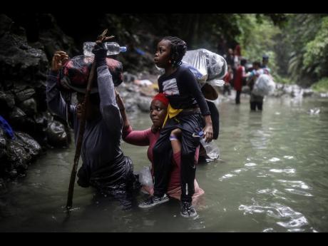 Haitian migrants wade through water as they cross the Darien Gap from Colombia to Panama in hopes of reaching the US. 