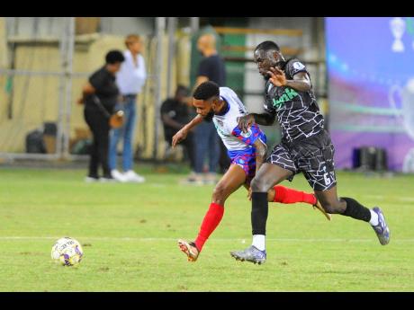 Jeovanni Laing (right) of Cavalier tackles Lamar Walker of Portmore United during the Lynk Cup final at Sabina Park, South Camp Road, Kingston, last Friday. Portmore won 2-0.