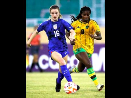 United States’ Jill Flammia (left) dribbling away from Jamaica’s Avery Johnson during their  Concacaf Under-20 Women’s Championship game at the Estadio Felix Sanchez in the Dominican Republic yesterday. The United States won 4-0.