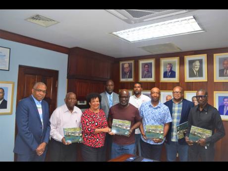Shipping Association of Jamaica Vice-President Corah Ann Robertson Sylvester presents copies of the body’s history book to the International Longshoremen’s Association and Clerical Administrative and Supervisory Employees delegates.