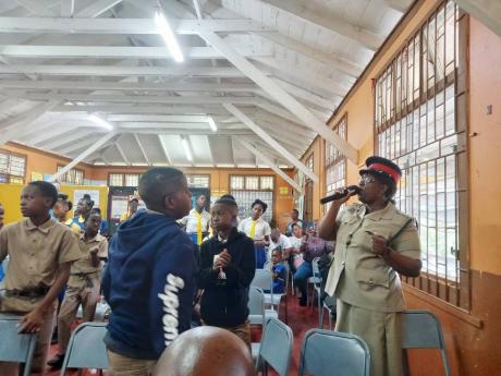 Principal of the Jamaica Constabulary Force Cadet Academy, Tanecia Johnson, engaging with students during her keynote address at the launch of the Robins Hall Primary Police Youth Club at the institution on Wednesday.