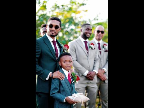 From left: Khamar and Luca Facey share a priceless father-son moment at the wedding alongside groomsmen Lebert Gordon and Shane Coore.