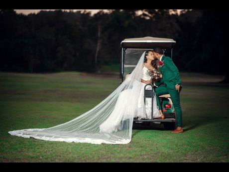 The beautiful couple share a kiss on the golf course. 