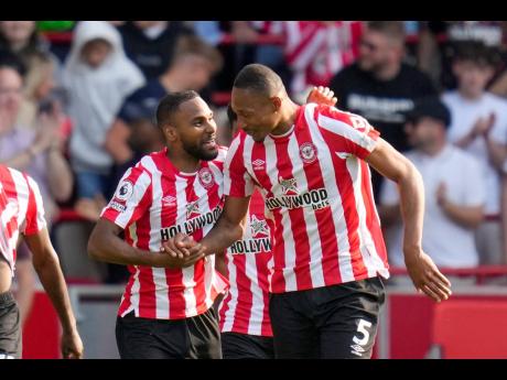 Brentford’s Ethan Pinnock (right) celebrates with Rico Henry after scoring against Manchester City  in the English Premier League on Sunday.