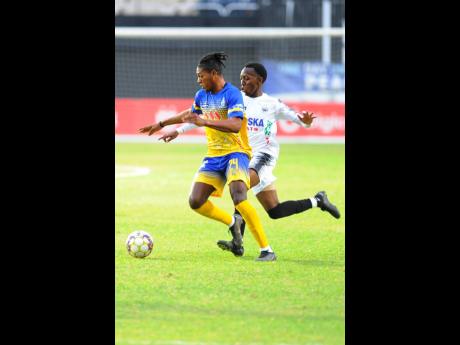 Dwayne Allen (right) of Cavalier tackles Rojay Smith of Harbour View FC during yesterday’s  Jamaica Premier League  first leg semi-final match at Sabina Park. Cavalier won 1-0.