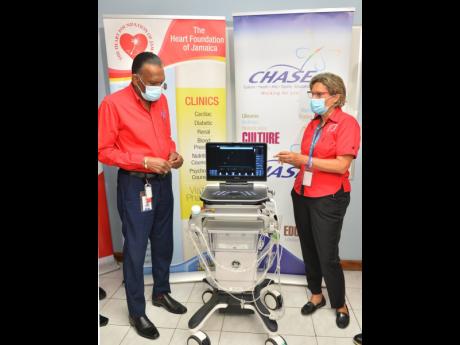 Chief Executive Officer of Culture, Health, Arts, Sports and Education (CHASE) Fund, W. Billy Heaven, and Executive Director, Heart Foundation of Jamaica (HFJ), Deborah Chen, converse following the recent handover of an echocardiogram machine to the HFJ in