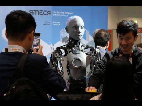 A robot designed by Engineers Arts and called Ameca  interacts with visitors during the International Conference on Robotics and Automation in London yesterday.