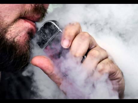 In this Friday, October 4, 2019, file photo, a man using an electronic cigarette exhales in Mayfield Heights, Ohio. The National Council on Drug Abuse says it has launched an intervention programme in Westmoreland to snuff out widespread vaping among stude