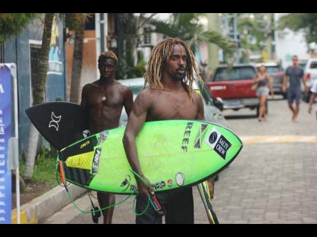 Jamaica’s Javaun Brown (left) and Icah Wilmot head to the beach at Surf City to practice ahead of the start of the ISA World Surfing Games in El Salvador.