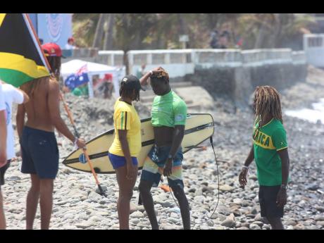 Jamaica's debutant surfer, Javaun Brown, is consoled by teammates after failing to advance to the second round of the World Surfing Games in El Salvador today.