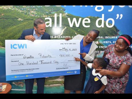 St Catherine Primary School teacher, Sanika Roberts (centre) receives a cheque from President of the Insurance Company of the West Indies (ICWI), Paul Lalor, while her student, Sarah-Kay Campbell and her mother Kerry Ann Francis Campbell look on. Roberts r