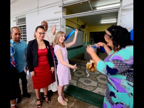 Maria Santamarina (centre), Food For The Poor’s director of government programmes, and Kayon Whyne (right), principal of Mt Alvernia High School in Montego Bay, St James, take part in a ribbon-cutting exercise during the inauguration ceremony for two ren