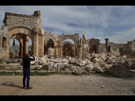 A man photographs the Church of Saint Simeon 30 kilometres north west of Aleppo, Syria.