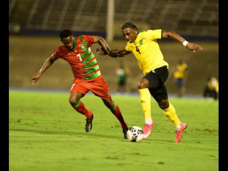 
Jamaica’s Amari’i Bell (right) tries to dribble past Suriname’s Marc Jozefroon during a Concacaf Nations League game between the teams at the National Stadium last year.