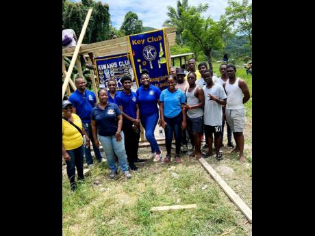 The team of Kiwanians, Key Clubbites, and members of Grace Food Processors pose for the cameras during a break from building a chicken coop at the Clifton Boys’ Home in Westmoreland. 