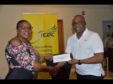 Dennis Hawthorne, managing director of Dennis Shipping and patron of the Miss Westmoreland Festival Queen 2023 Competition, presents an undisclosed financial donation to Carlene Rumbolt, chairman of the Jamaica Cultural Development Commission, Westmoreland