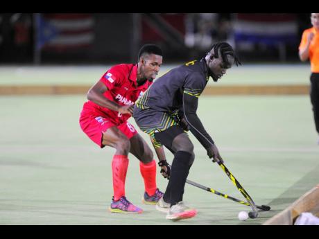 Eduardo Gordon (left) of Panama tries to steal the ball from Jamaica’s Christopher Reid during their Pan American Hockey 5s match at the Mona Hockey Field yesterday. Jamaica won 3-1.