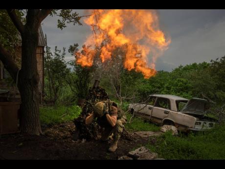 A Ukrainian soldier fires a mortar at Russian positions on the frontline near Bakhmut, Donetsk region, Ukraine, on May 28, 2023. The global economy is likely to slow sharply this year, hobbled by high interest rates and the war.