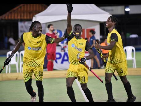 George McGlashen (left) and Kevon Reid (right) help Gian-Paul Haughton celebrate a Pan American Cup Hockey5s goal against Puerto Rico at the Mona Hockey Field yesterday. Jamaica won the match 3-2.