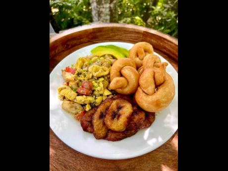 This ackee and salt fish dish is served with fried dumplings and fried ripe plantains.