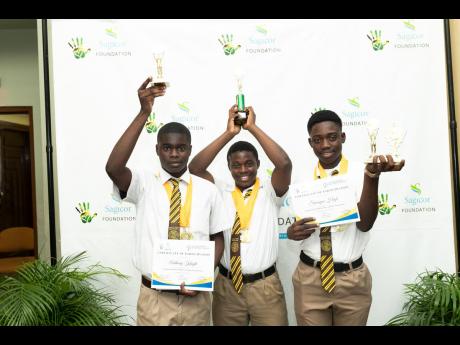 Top performers in the Joy Town Community Development Foundation’s Youth with GRIT Programme (from left) Anthony Knight, Julis Clarke and Suwayne High celebrate with the trophies and medals they received during the programme’s graduation ceremony on Tue