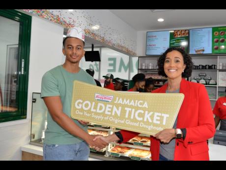 Lisa Lake (right), group chief executive officer at Lake Group of Companies and director of Restaurant Associates Limited, presented the golden ticket to Adam Bogle, for being the first person on-site to enter the newly opened Krispy Kreme franchise last S